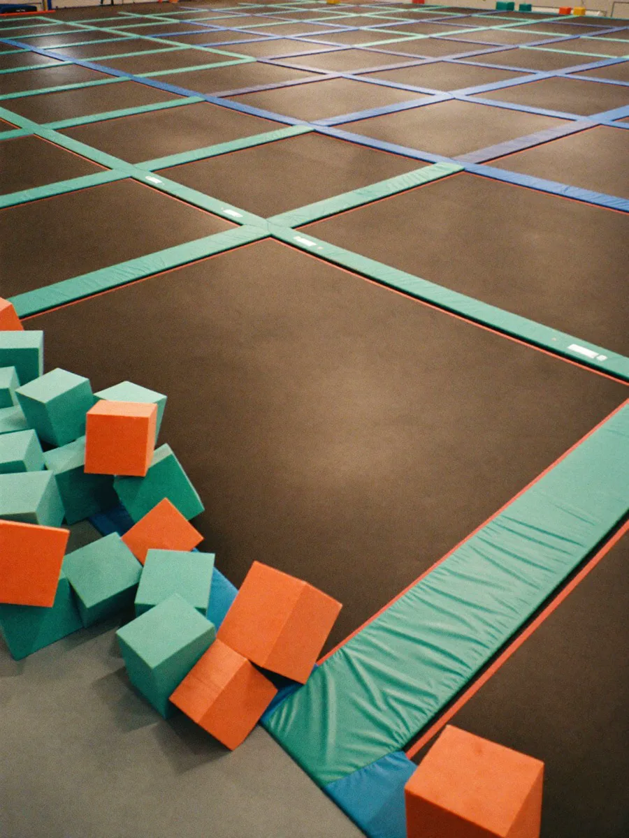 A bright, colorful indoor trampoline park with padded courts